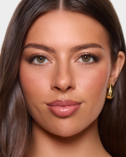 Woman with long brown hair and gold earrings wearing Dimple Color Acacia Olive color contact lenses