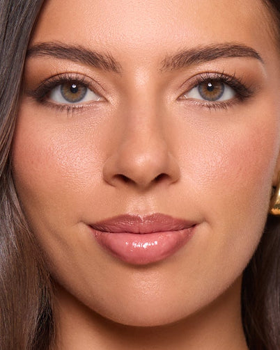 Woman with long brown hair and gold earrings wearing Dimple Color's Saba Grey color contact lenses