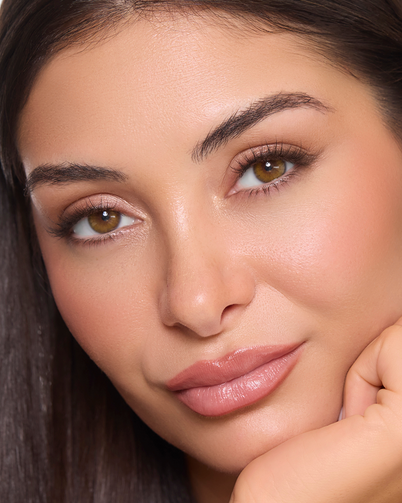 Woman with long, straight hair against a plain background wearing Dimple Color's Savanna Hazel color contact lenses